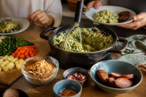 Pan stamppot op een keukentafel met losse toppings en groenten