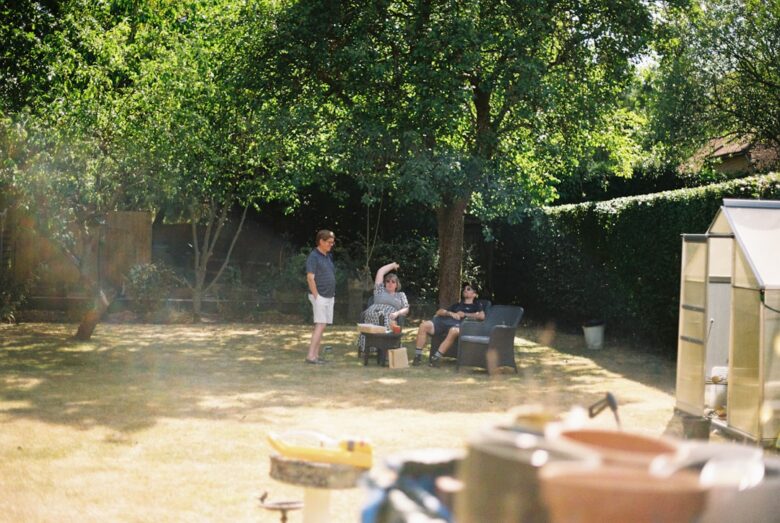 Three children relaxing in a sunny backyard